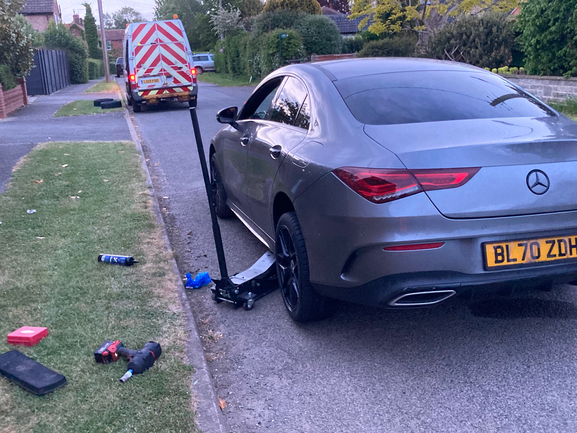 Rear wheel service on a grey Mercedes CLA at a residential kerbside
